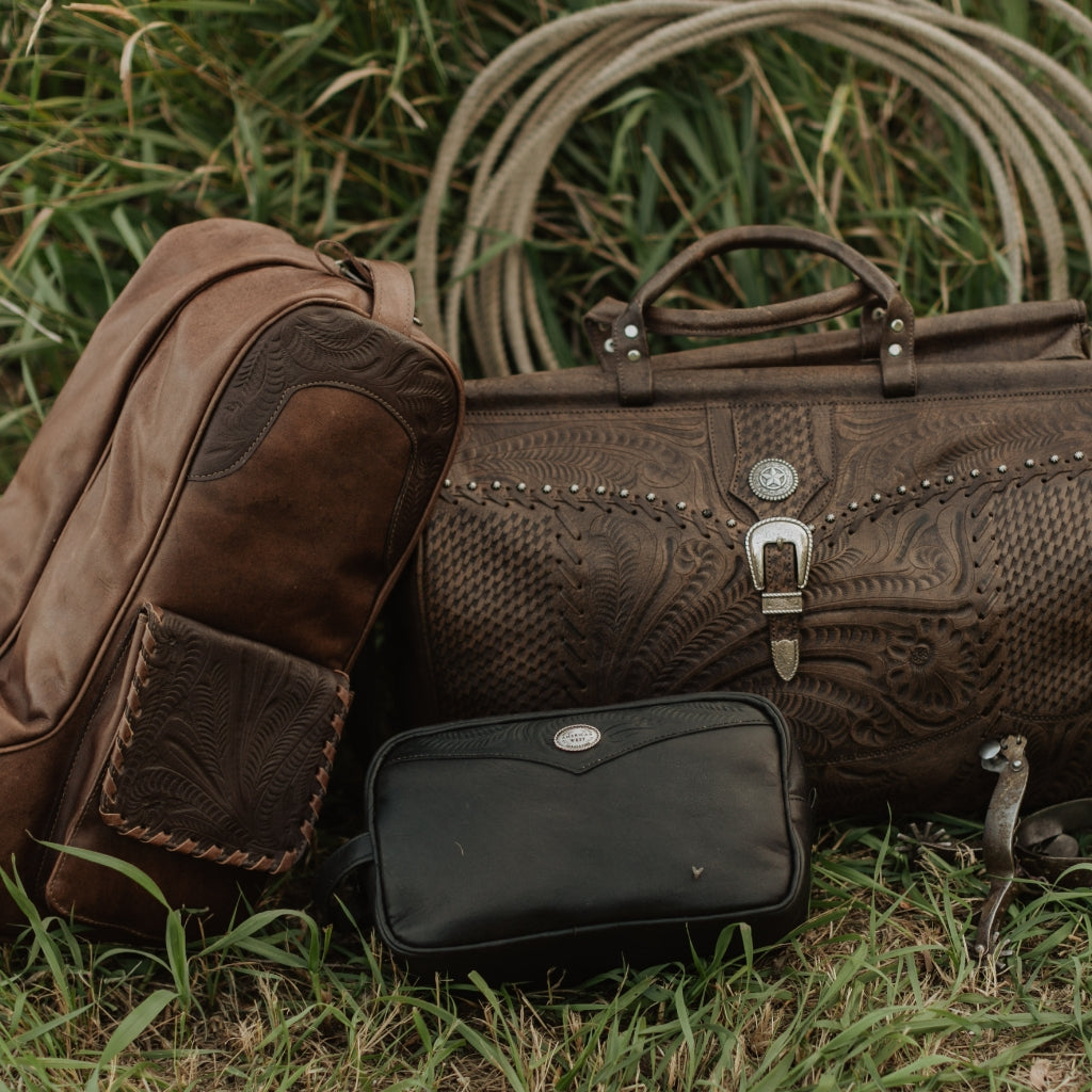 American West Handcrafted Leather western travel bags featuring tooled leather duffle bags, leather boot bags, and handcrafted travel accessories