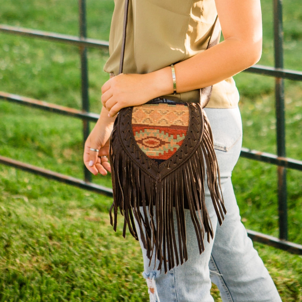 American West leather warehouse sale featuring western fringe crossbody bag with woven southwest pattern and handcrafted leather detailing