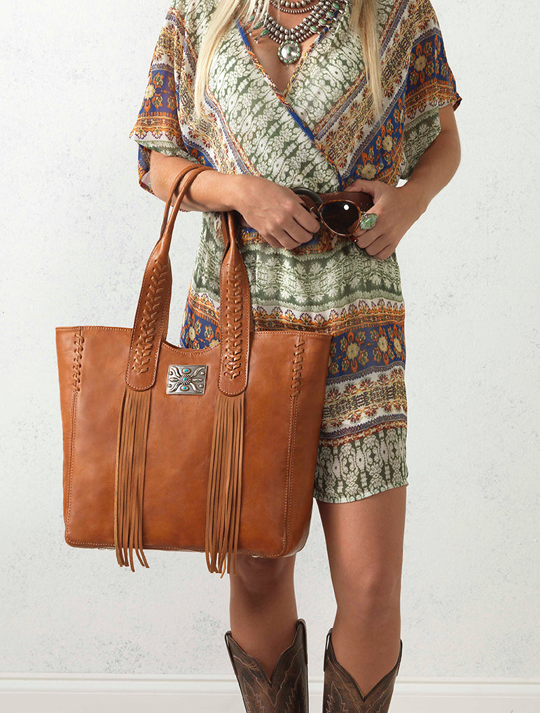 Lifestyle with model of Mohave Canyon tote in natural tan with concho and leather fringe accents