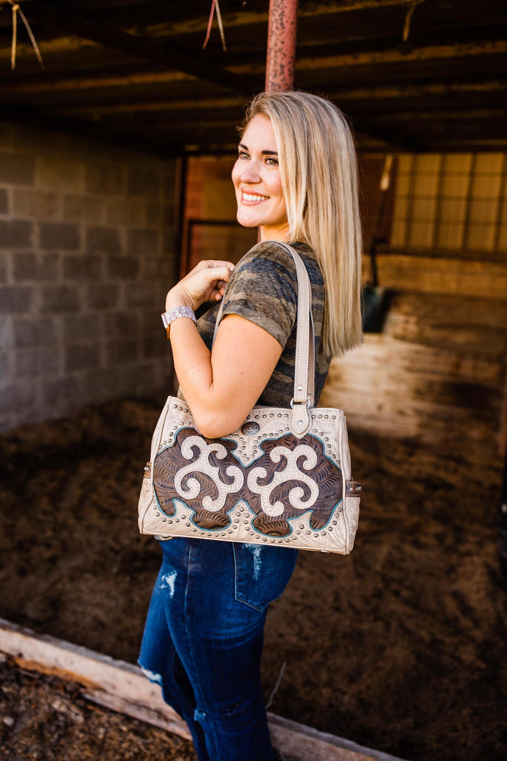 Lifestyle with model of Annie's Secret multi-compartment conceal carry tote in sand with hand tooled leather accents