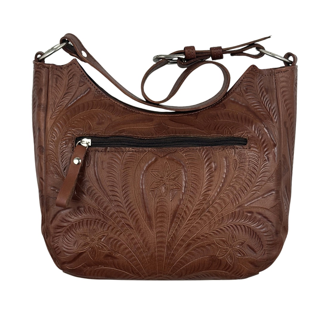 Back view of brown tooled leather shoulder bag with an embossed floral pattern, a front zippered pocket, and a matching leather strap, shown against a plain white background.
