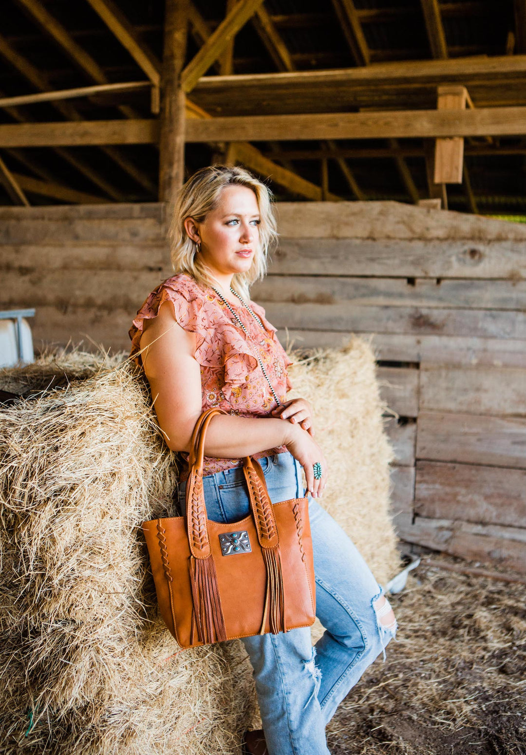 Lifestyle with model of Mohave Canyon tote in natural tan with concho and leather fringe accents