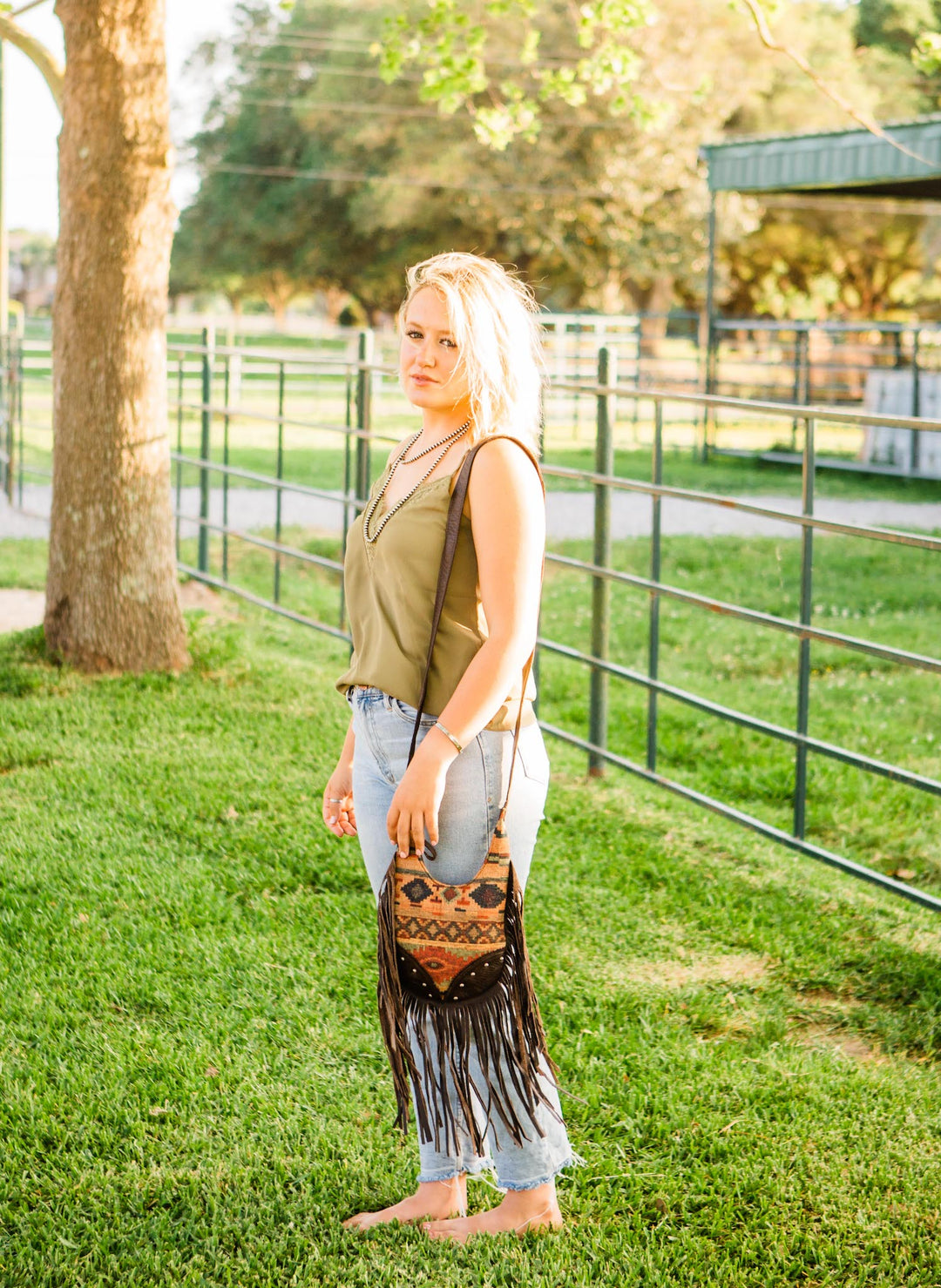 Lifestyle with model of Fringed Cowgirl crossbody in woven tapestry with fringe accent