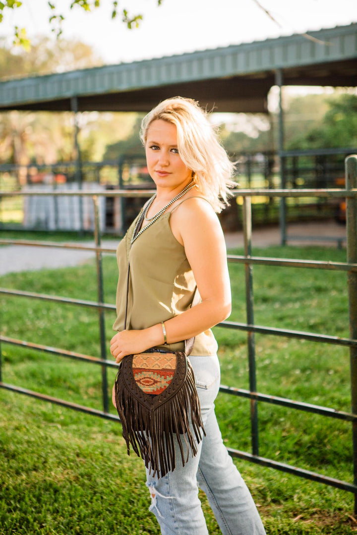 Lifestyle with model of Fringed Cowgirl crossbody in woven tapestry with fringe accent