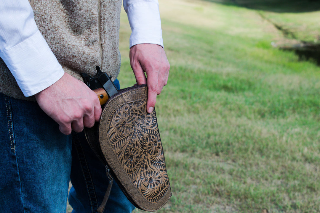 Lifestyle with model of Padded Gun Case in distressed charcoal brown with hand tooled leather accents