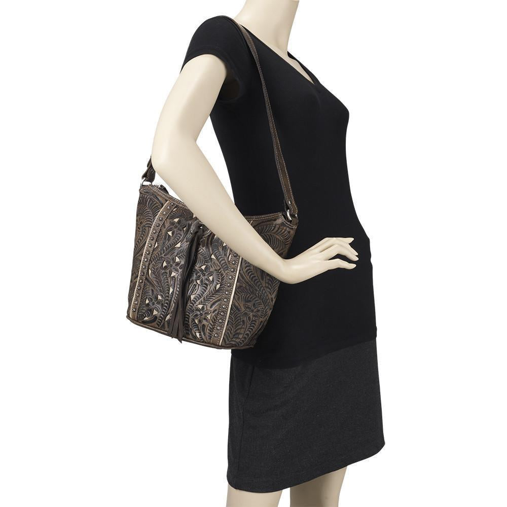 Hill Country bucket tote in distressed charcoal brown with hand tooled leather accents and bolo concho with tassel on mannequin