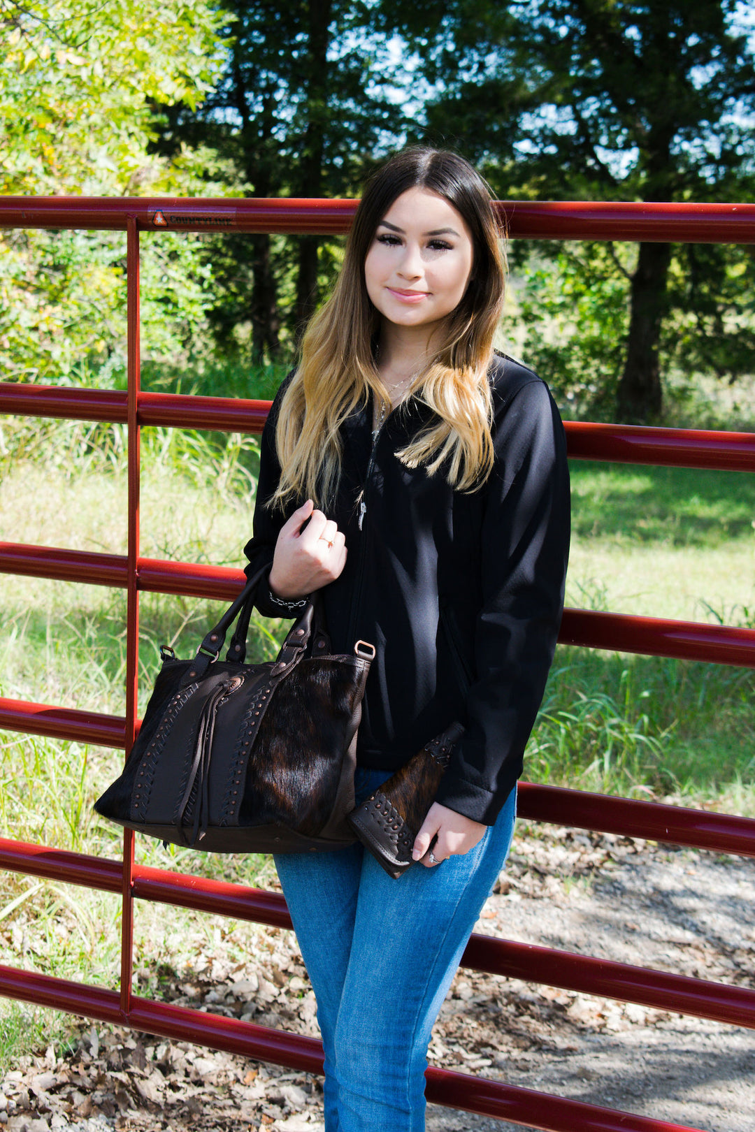 Lifestyle with model of Cow Town conceal carry convertible satchel in brindle with hair-on hide leather accents