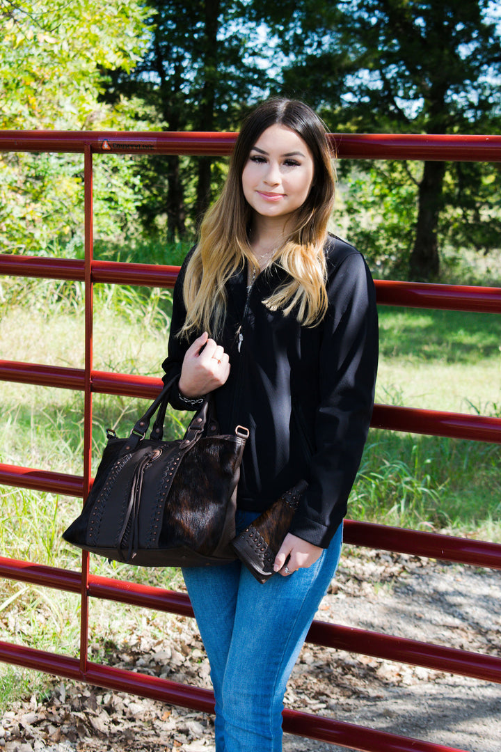 Lifestyle with model of Cow Town conceal carry convertible satchel in brindle with hair-on hide leather accents