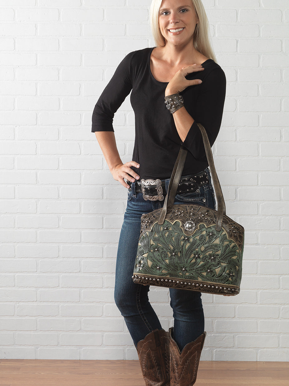 Lifestyle with model of Annie's Secret conceal carry tote in light turquoise with hand tooled leather and cut out accents