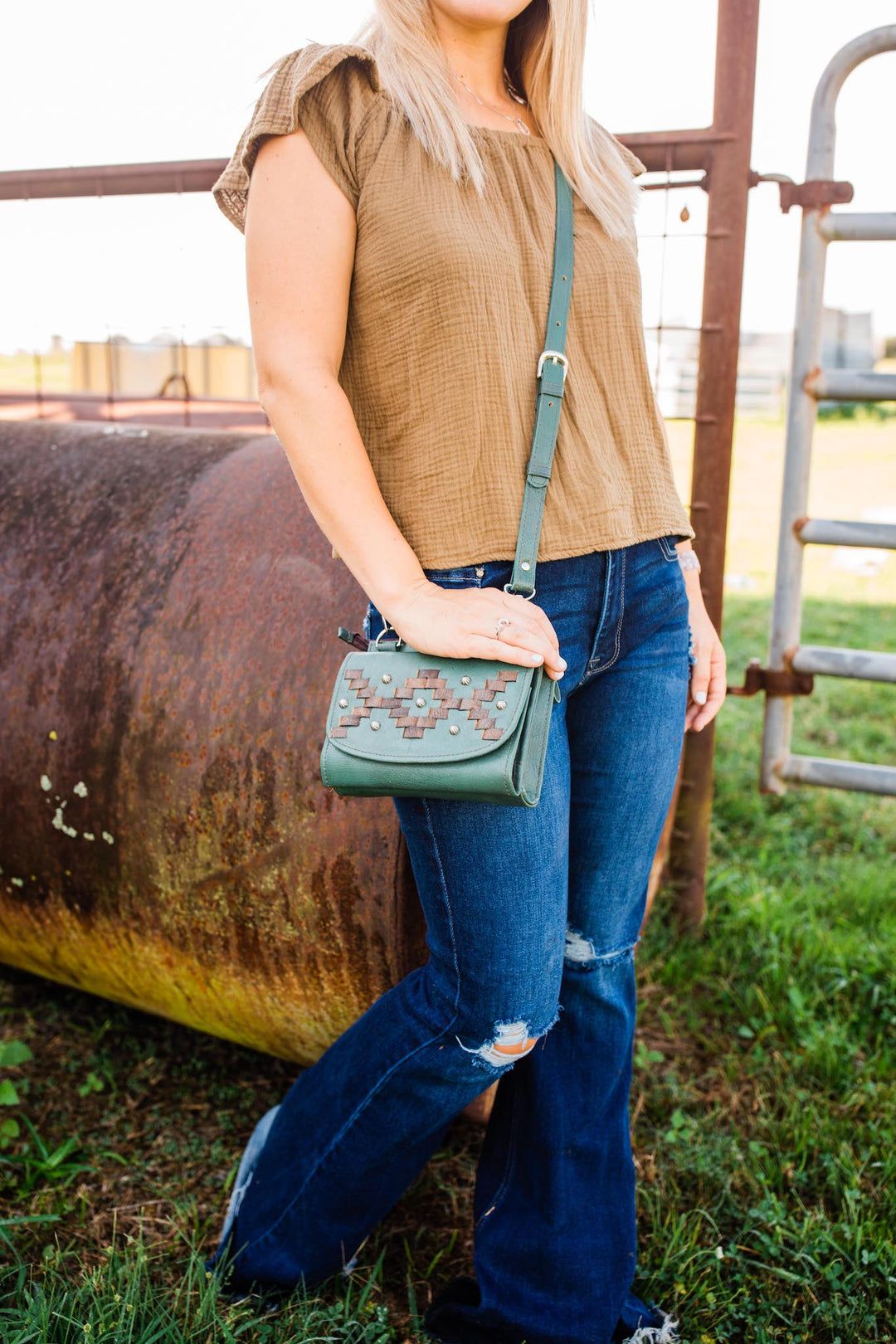 Lifestyle with model of Tribal Weave crossbody bag in light turquoise with leather stitching accents