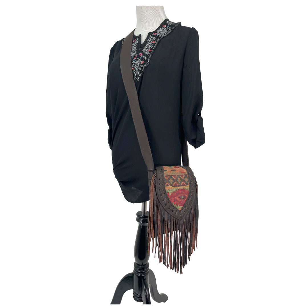 Fringed Cowgirl crossbody in woven tapestry with fringe accent on a mannequin