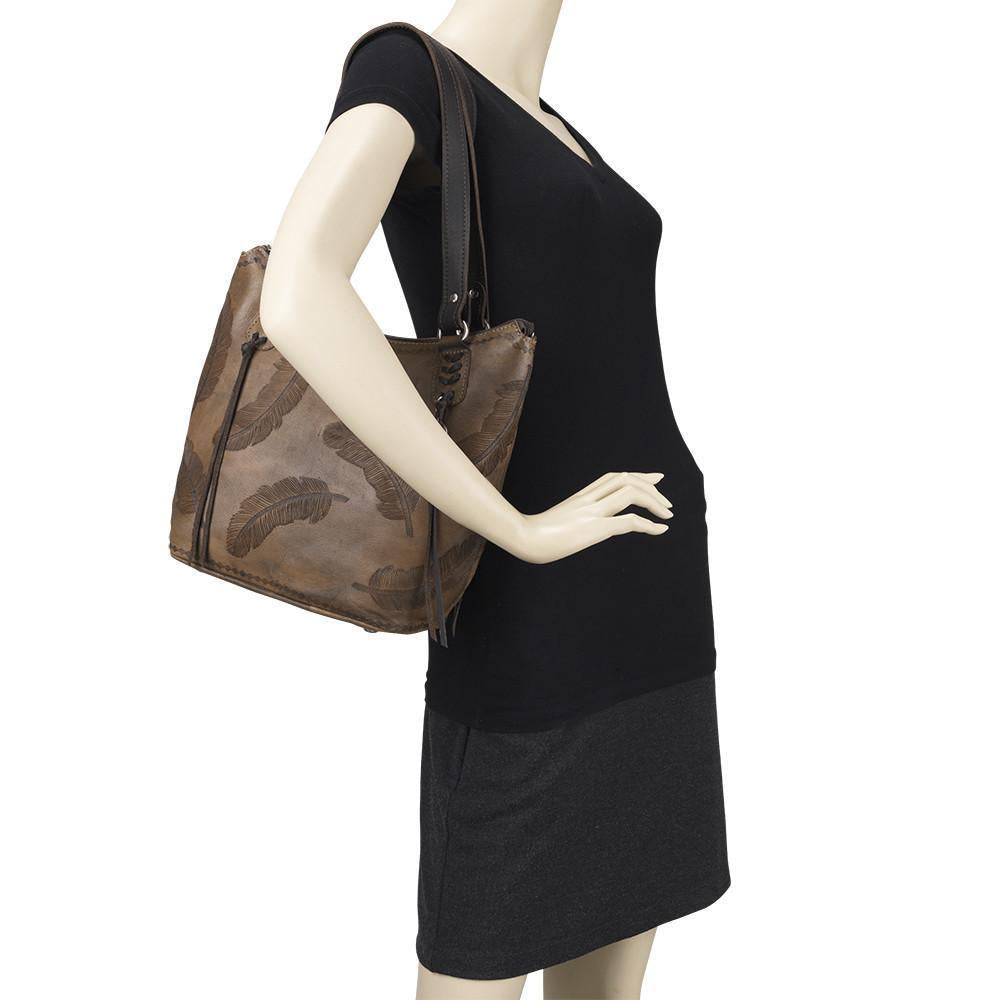 Sacred Bird bucket tote in distressed charcoal brown leather with hand tooled feathers on mannequin