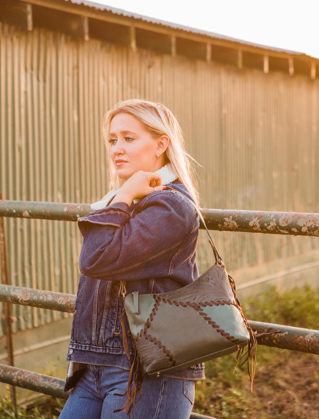 Lifestyle with model of Gypsy Patch shoulder bag in light turquoise with hand tooled leather accents