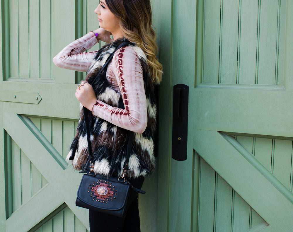 Lifestyle with model of Midnight Copper crossbody bag in black with hand tooled accents