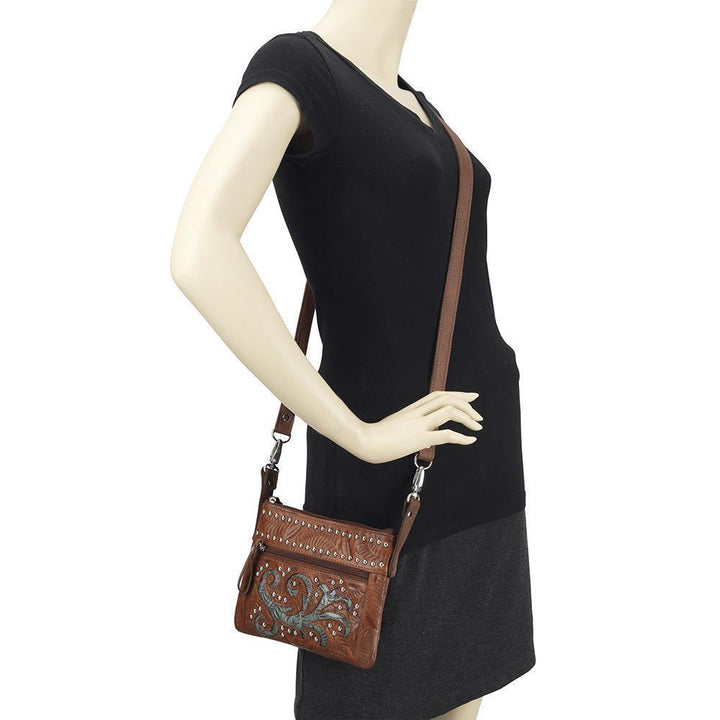 Prairie Sage crossbody/hip bag in medium brown with hand tooled leather pattern and horse head on mannequin
