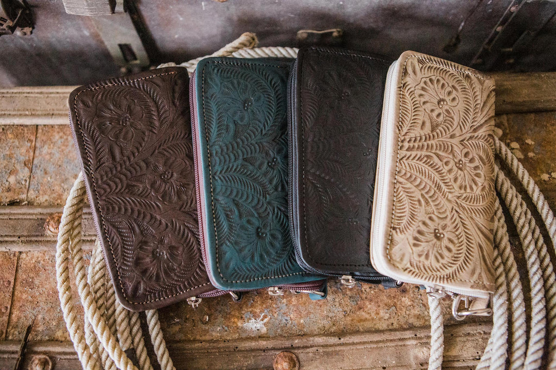 Assorted colors of Ladies zip-around wallet with hand tooled leather accents on chest with rope