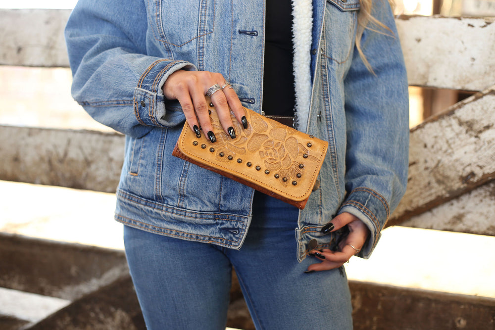 Lifestyle with model of Texas Rose tri-fold wallet in natural tan with hand tooled leather accents