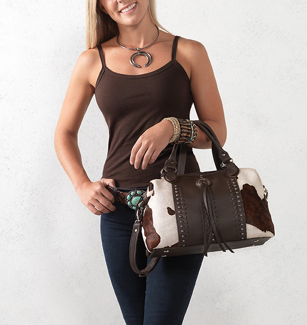 Lifestyle with model of Cow Town conceal carry convertible satchel in pony with hair-on hide leather accents