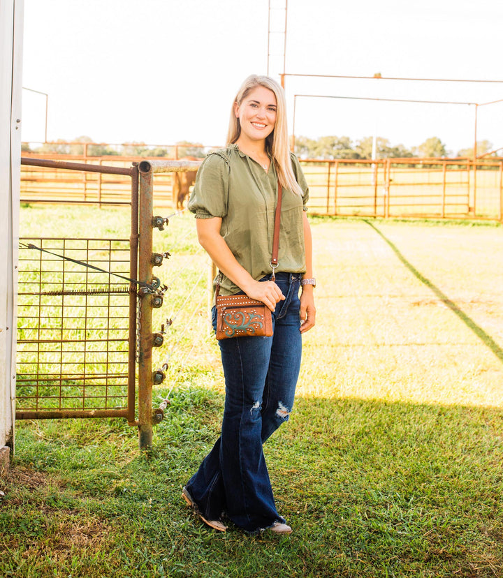 Lifestyle with model of Prairie Sage crossbody/hip bag in medium brown with hand tooled leather accents