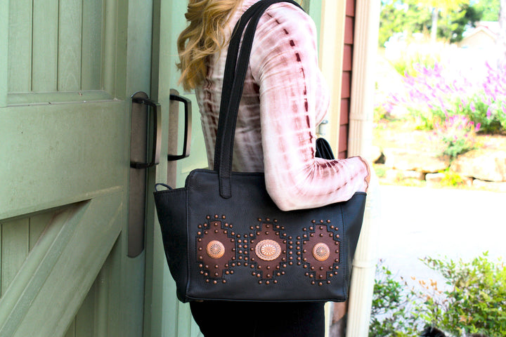 Lifestyle with model of Midnight Copper conceal carry tote in black with hand tooled accents