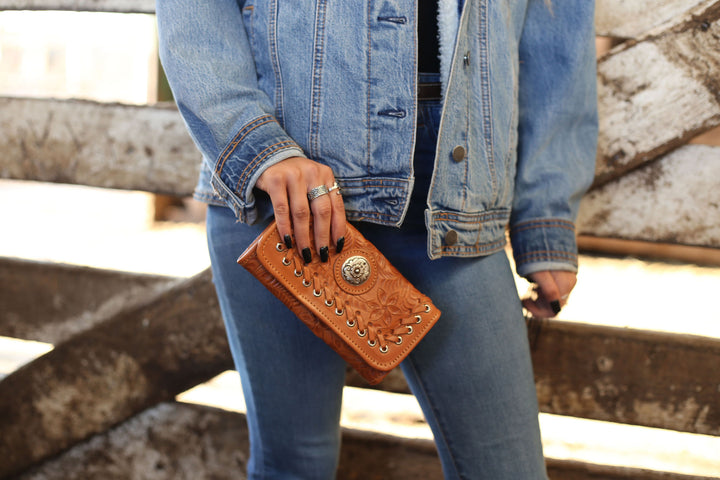 Lifestyle with model of Harvest Moon tri-fold wallet in natural tan with hand tooled leather accents