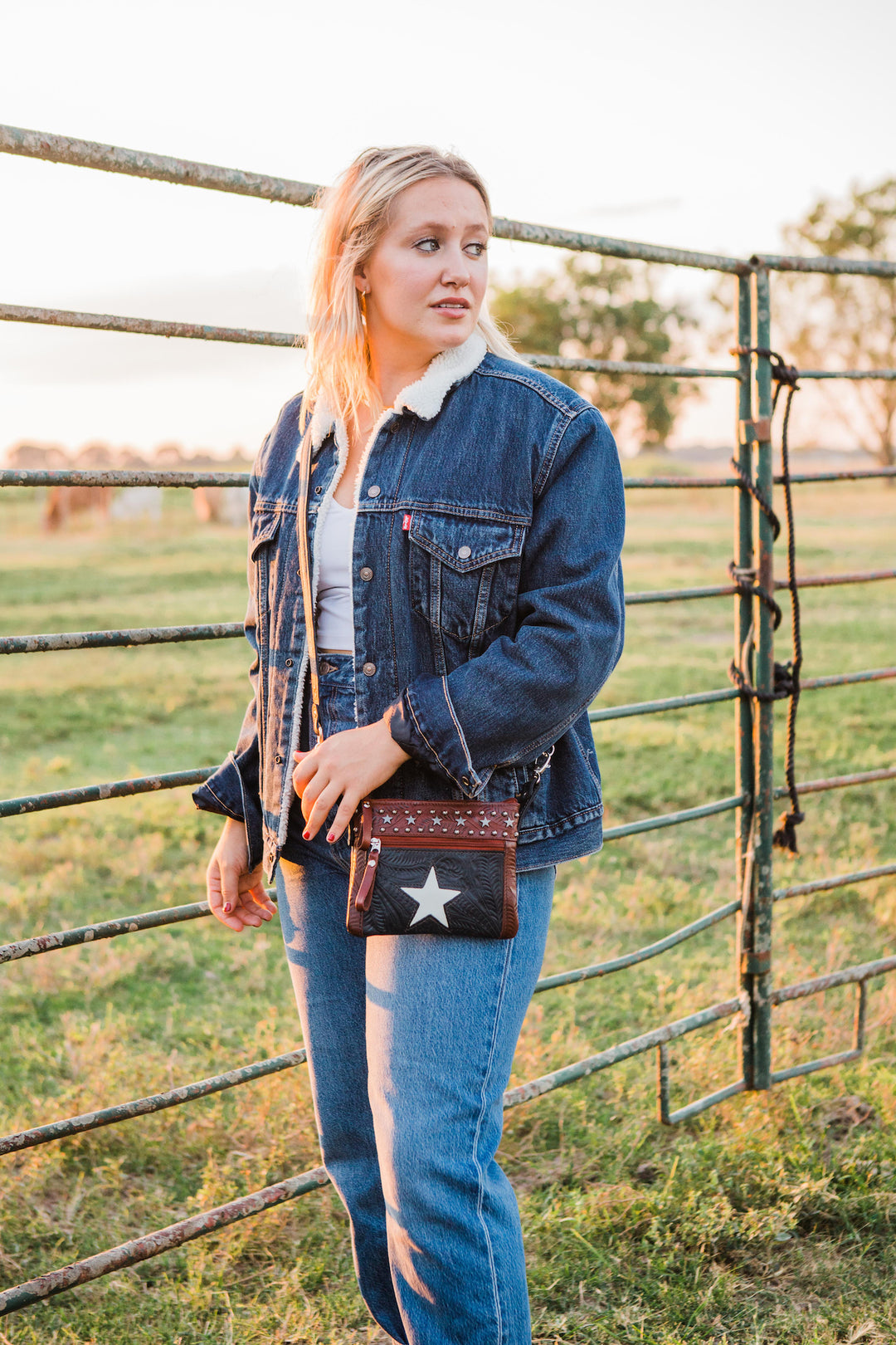 Lifestyle with model of Lone Star crossbody/hip bag in navy blue with hand tooled leather accents